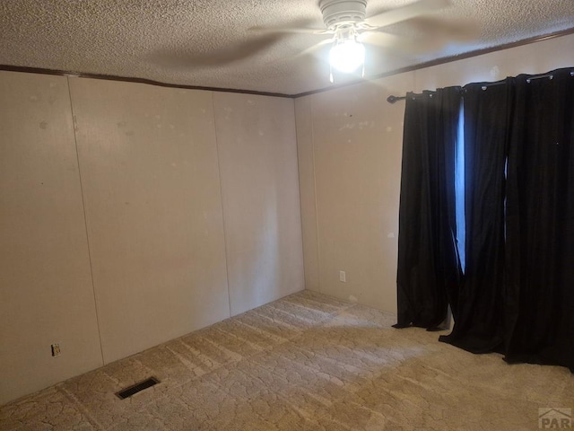 1106 10th St, Las Animas, CO 81054 - carpeted spare room with a textured ceiling, ceiling fan, and a decorative wall