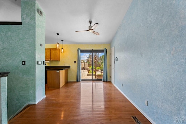 853 S Blakeland Dr, Pueblo West, CO 81007 - unfurnished living room featuring ceiling fan, wood finished floors, and a textured wall