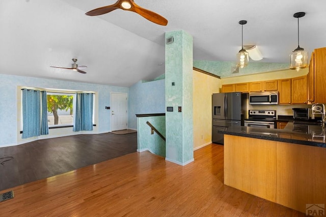 853 S Blakeland Dr, Pueblo West, CO 81007 - kitchen with stainless steel appliances, open floor plan, a ceiling fan, lofted ceiling, and wood finished floors