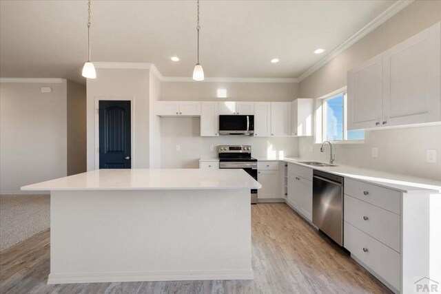 kitchen with appliances with stainless steel finishes, a center island, and light countertops