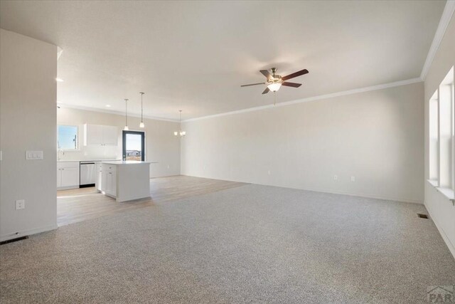 unfurnished living room featuring a ceiling fan, light colored carpet, visible vents, and crown molding