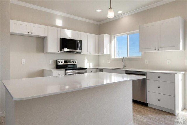 kitchen with a kitchen island, appliances with stainless steel finishes, and light countertops