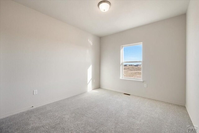 carpeted spare room with visible vents