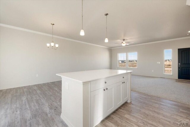 kitchen featuring white cabinets, open floor plan, light countertops, a center island, and pendant lighting