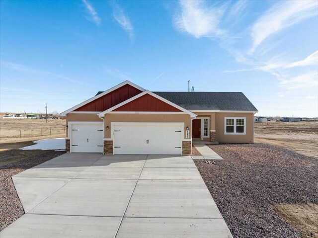 view of front of property with stucco siding, a shingled roof, concrete driveway, an attached garage, and stone siding