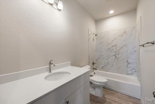 bathroom featuring tub / shower combination, vanity, toilet, and wood finished floors