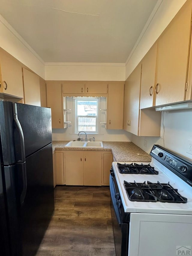 kitchen with dark wood finished floors, light countertops, a sink, freestanding refrigerator, and white range with gas cooktop
