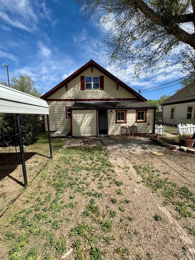 rear view of house with fence, driveway, and a garage