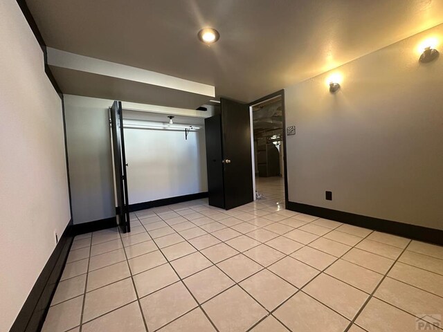 unfurnished room featuring baseboards and light tile patterned floors