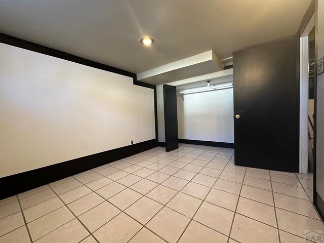 spare room featuring light tile patterned flooring and baseboards