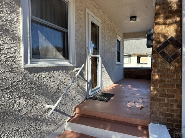 property entrance with stucco siding