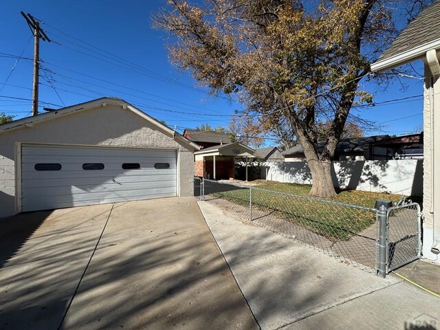 view of front facade featuring a gate, a front yard, fence, and a detached garage