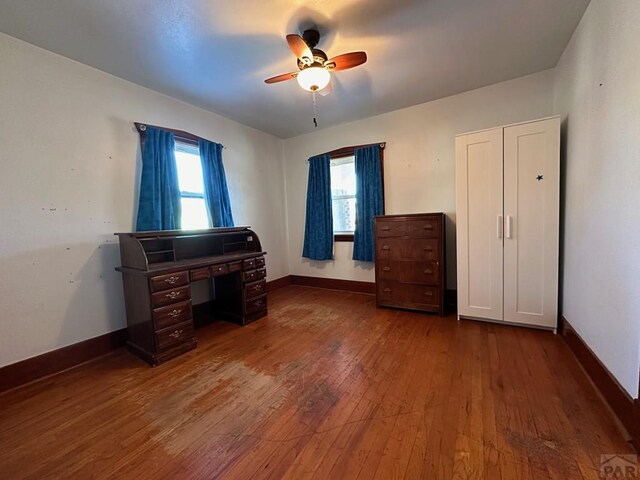 office featuring ceiling fan, baseboards, and wood finished floors