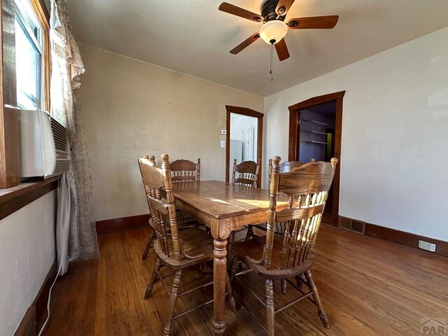 dining room featuring a ceiling fan, visible vents, baseboards, and wood finished floors