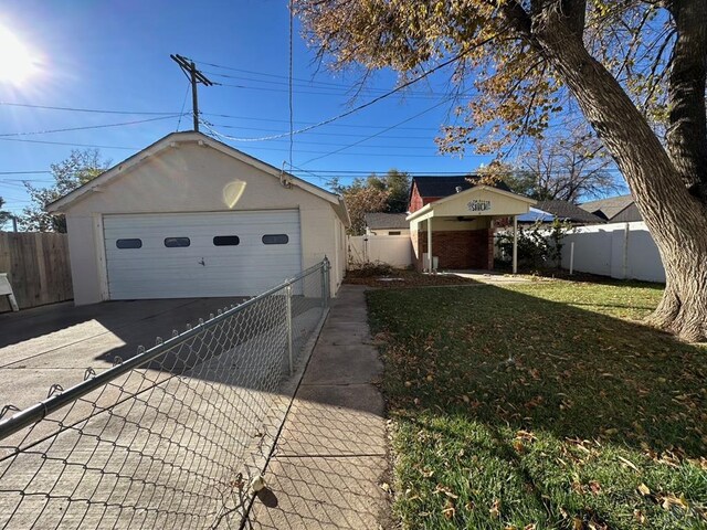 view of front facade with a front lawn, fence, a detached garage, and an outdoor structure