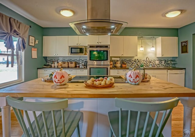 180 Welton Ave, Walsenburg, CO 81089 - kitchen with stainless steel appliances, wooden counters, wood finished floors, decorative backsplash, and a breakfast bar area