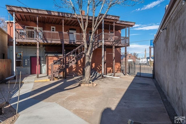 901 E C St, Pueblo, CO 81003 - back of house featuring a patio area, fence, stairway, and brick siding