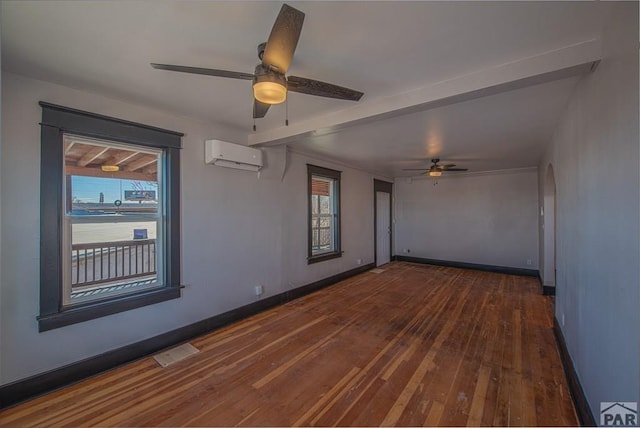 901 E C St, Pueblo, CO 81003 - empty room featuring ceiling fan, a wall unit AC, dark wood-style flooring, visible vents, and baseboards