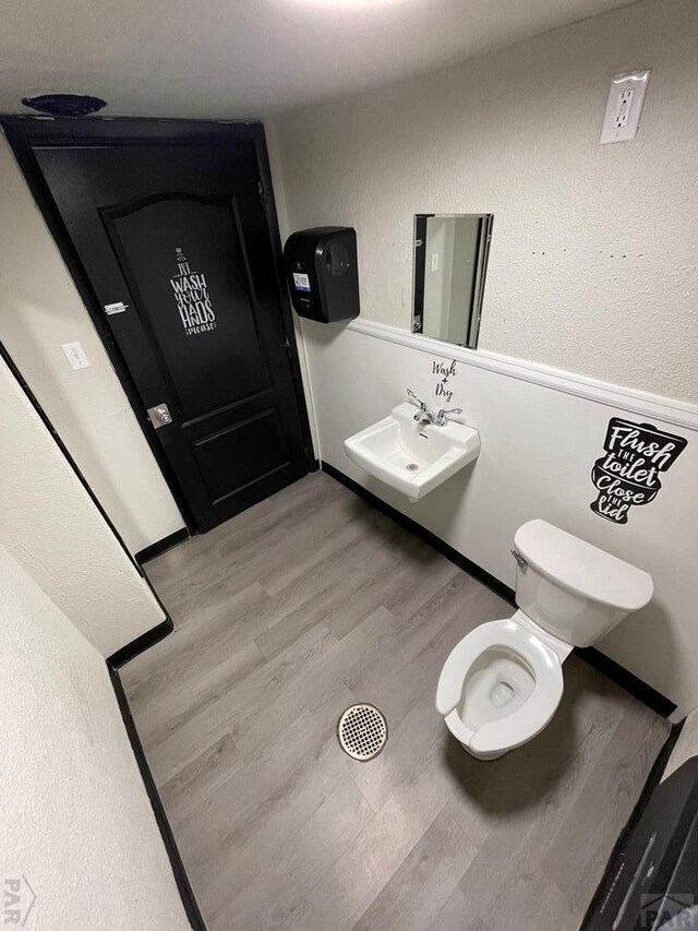 901 E C St, Pueblo, CO 81003 - half bathroom with wood finished floors, a sink, and toilet