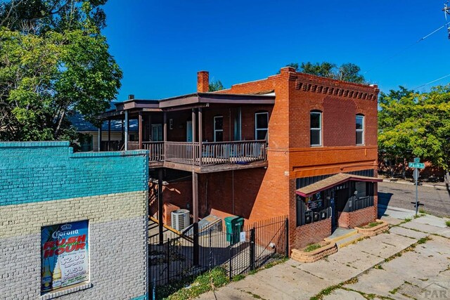 exterior space with a chimney, fence, and brick siding