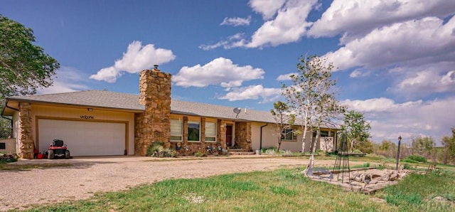 single story home with driveway, a chimney, and an attached garage