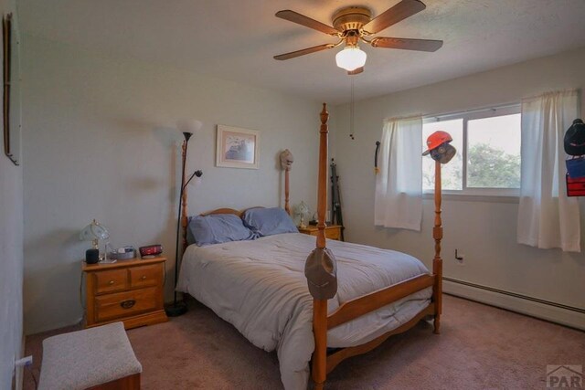 bedroom with light carpet, a baseboard radiator, and a ceiling fan