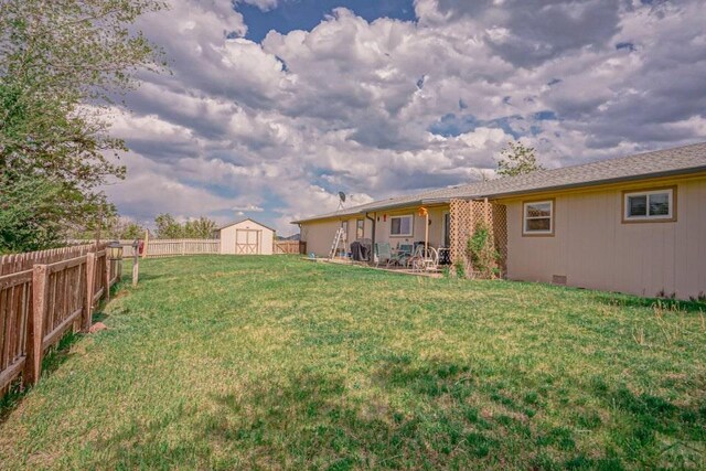 view of yard featuring a fenced backyard, an outdoor structure, and a storage unit