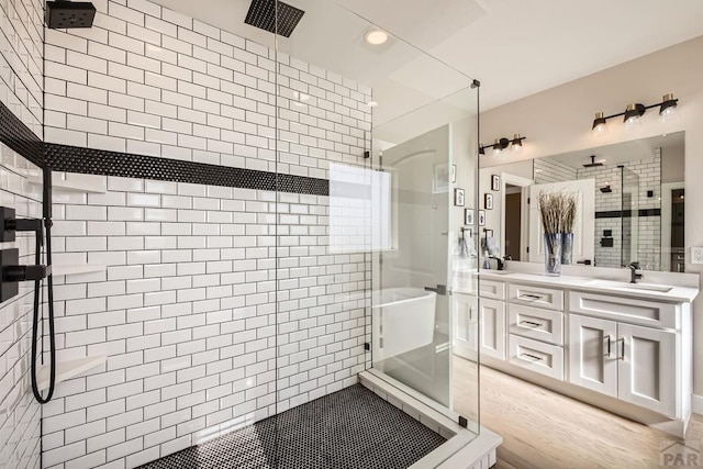 full bath featuring a sink, double vanity, and a shower stall