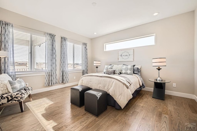 bedroom with recessed lighting, wood finished floors, and baseboards