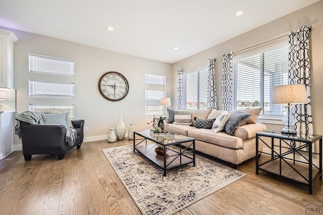 living room with light wood finished floors, recessed lighting, and baseboards