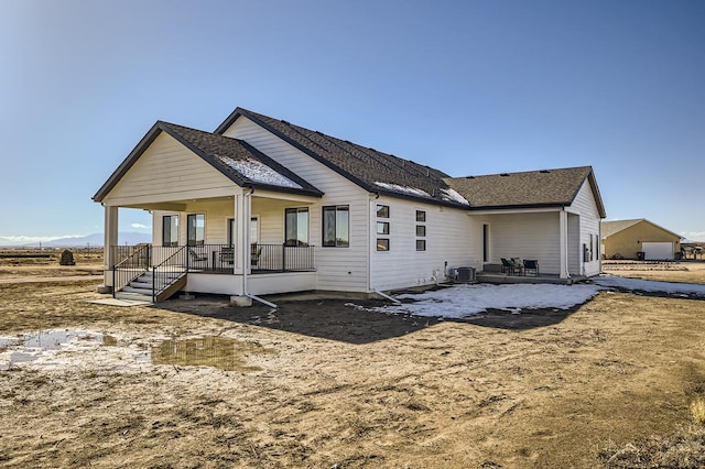 rear view of property featuring covered porch