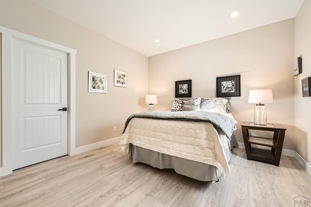 bedroom with recessed lighting, light wood-style flooring, and baseboards