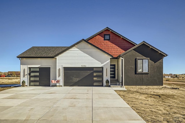 view of front facade with a garage, roof with shingles, and driveway