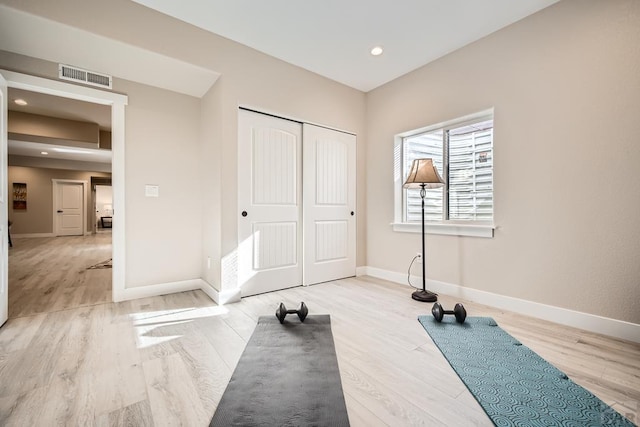 exercise area with recessed lighting, baseboards, visible vents, and light wood finished floors