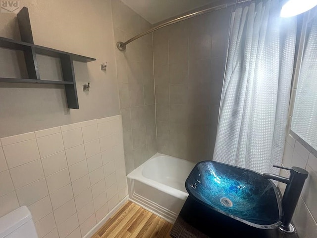 full bathroom with toilet, shower / washtub combination, tile walls, and wood finished floors