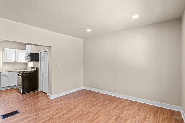 interior space featuring light countertops, visible vents, appliances with stainless steel finishes, light wood-style floors, and white cabinets