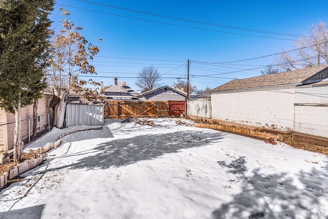 yard layered in snow featuring a fenced backyard