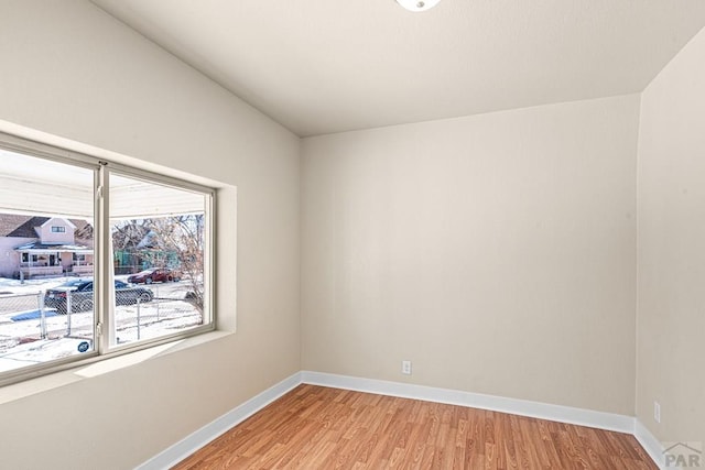 unfurnished room with baseboards and light wood-style floors