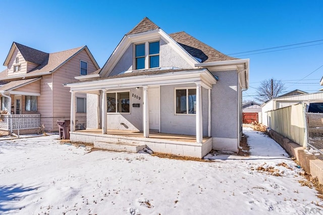 bungalow-style home with a shingled roof, a porch, and fence