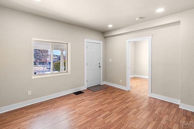 empty room with light wood finished floors, baseboards, visible vents, and recessed lighting