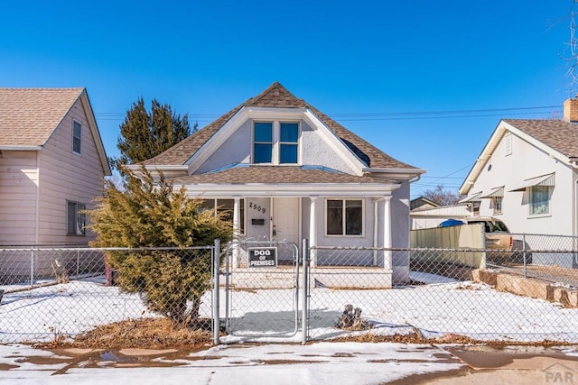 view of front of property featuring a fenced front yard, a gate, and a shingled roof