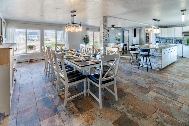 dining area with stone tile flooring, a textured ceiling, and ceiling fan