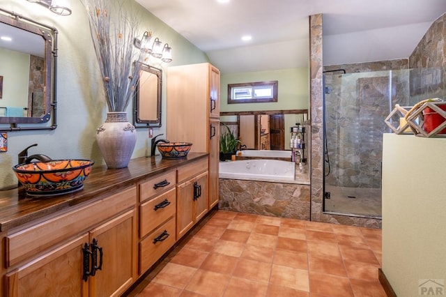 full bath with double vanity, a bath, a stall shower, and a sink