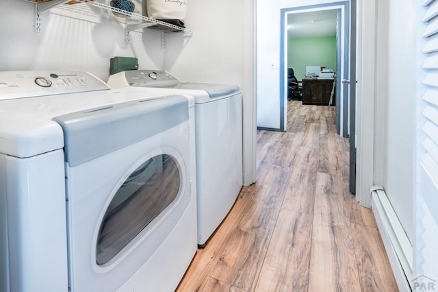 laundry room featuring a baseboard radiator, washer and dryer, light wood-style floors, and laundry area