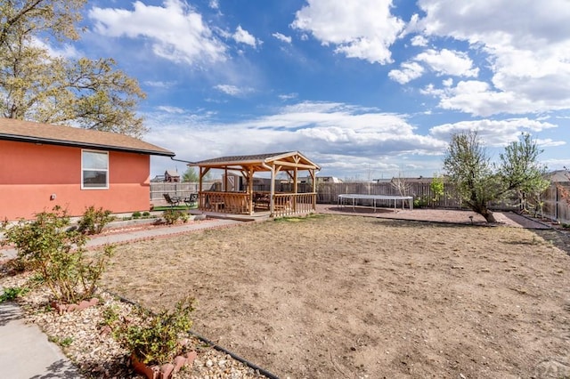 view of yard with a gazebo, a trampoline, and a fenced backyard