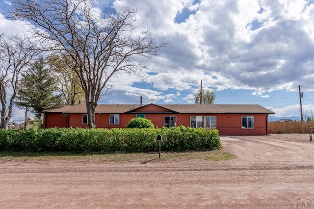 ranch-style house with driveway and fence