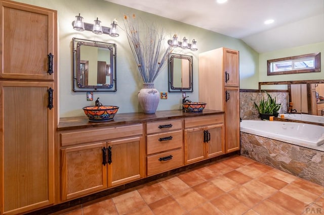 full bath featuring a bath, lofted ceiling, double vanity, and a sink