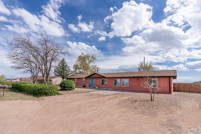 single story home featuring fence