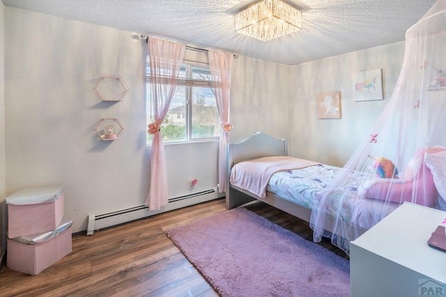 bedroom with a baseboard radiator, a chandelier, wood finished floors, and a textured ceiling