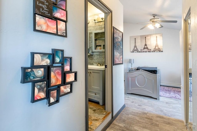 hall featuring a baseboard heating unit and wood finished floors